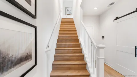 a view of staircase with wooden floor and white walls