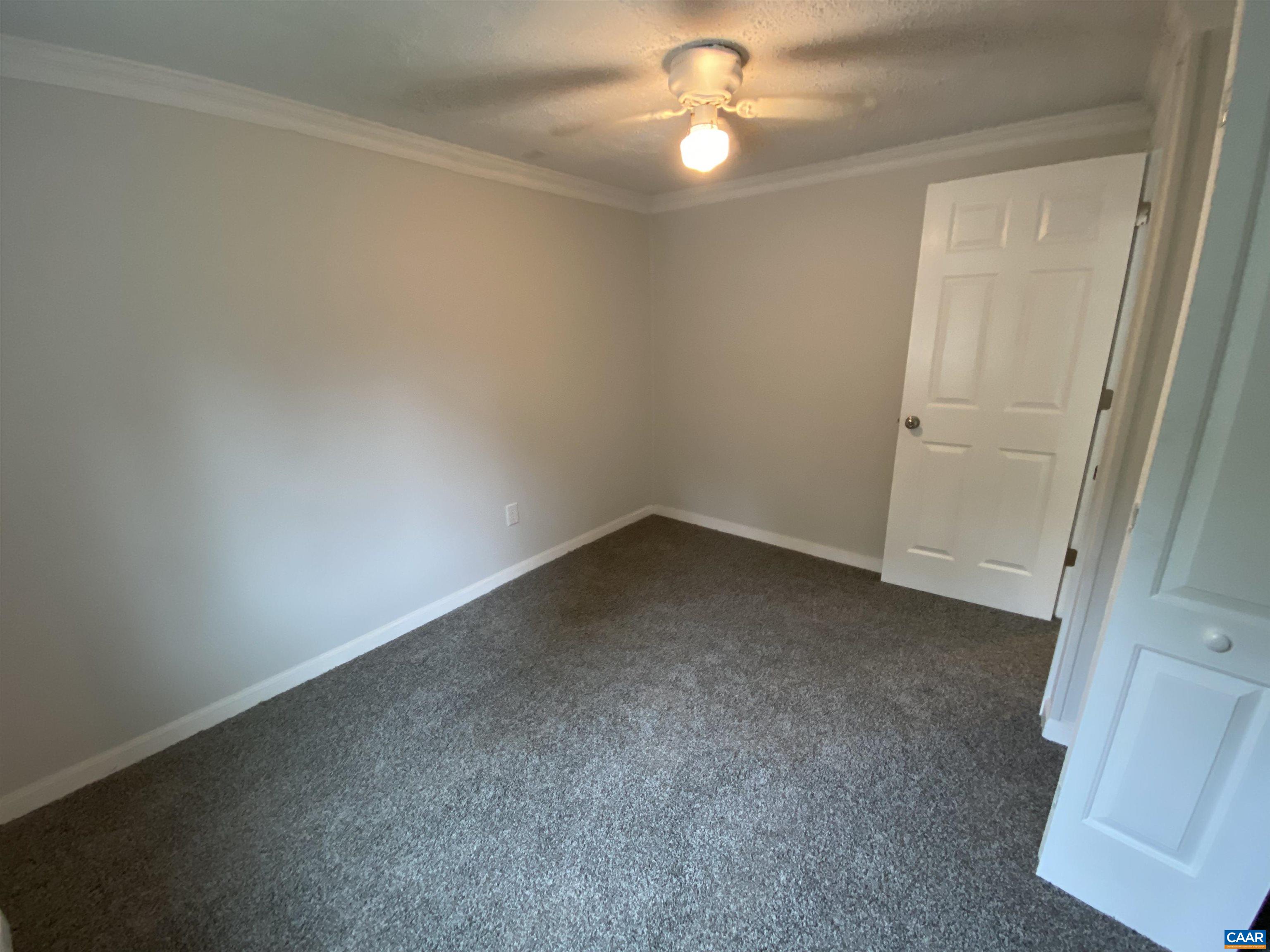 193 Rock Road New Canton, VA 23123 - Photo 7 of 12 an empty room with a chandelier fan and windows
