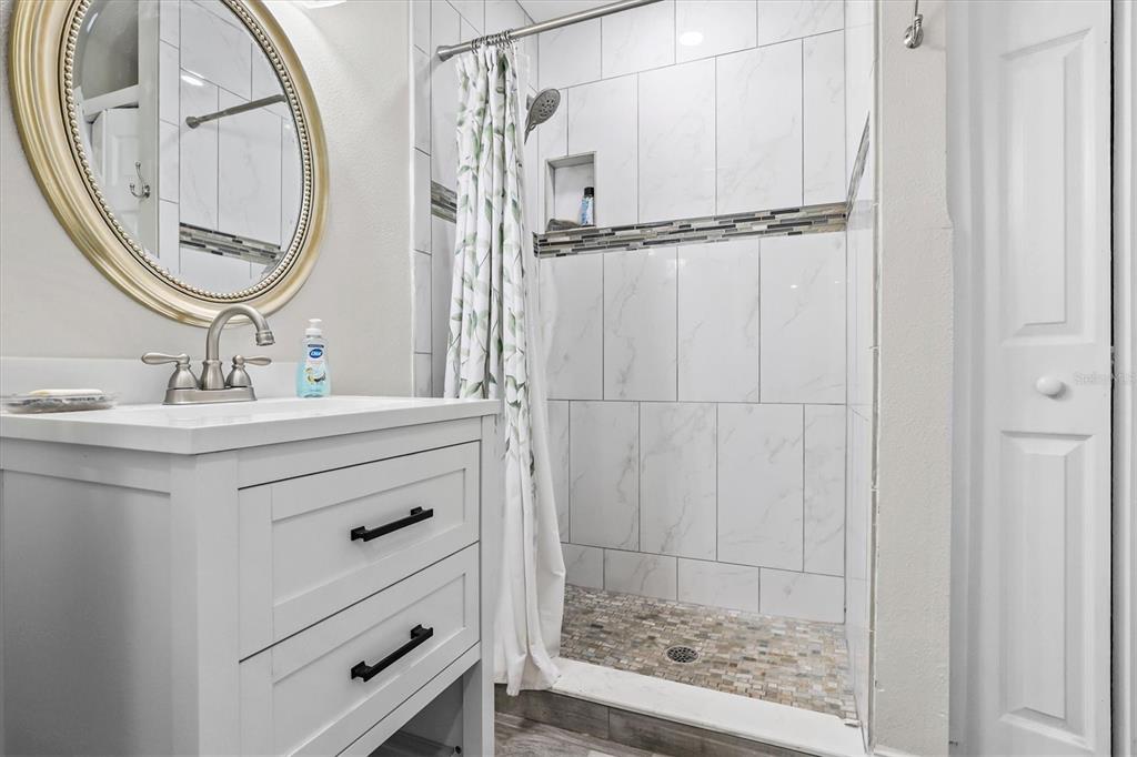 6244 Colony Circle Weeki Wachee, FL 34607 - Photo 53 of 60 a bathroom with a sink a vanity a mirror and a shower
