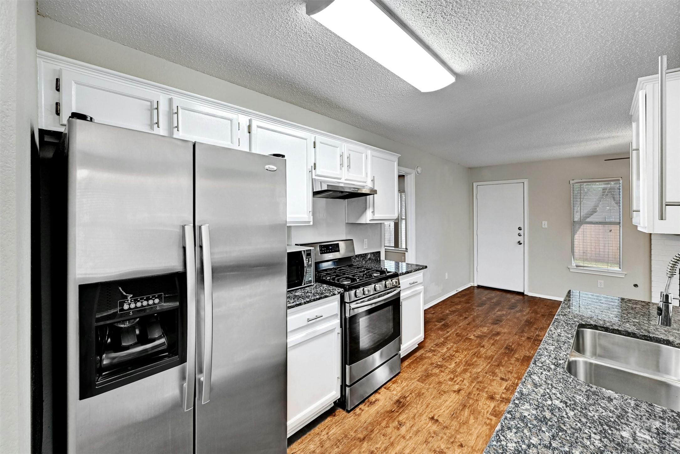 1807 Hollow Tree Boulevard Round Rock, TX 78681 - Photo 15 of 40 a kitchen with stainless steel appliances granite countertop a refrigerator stove and sink