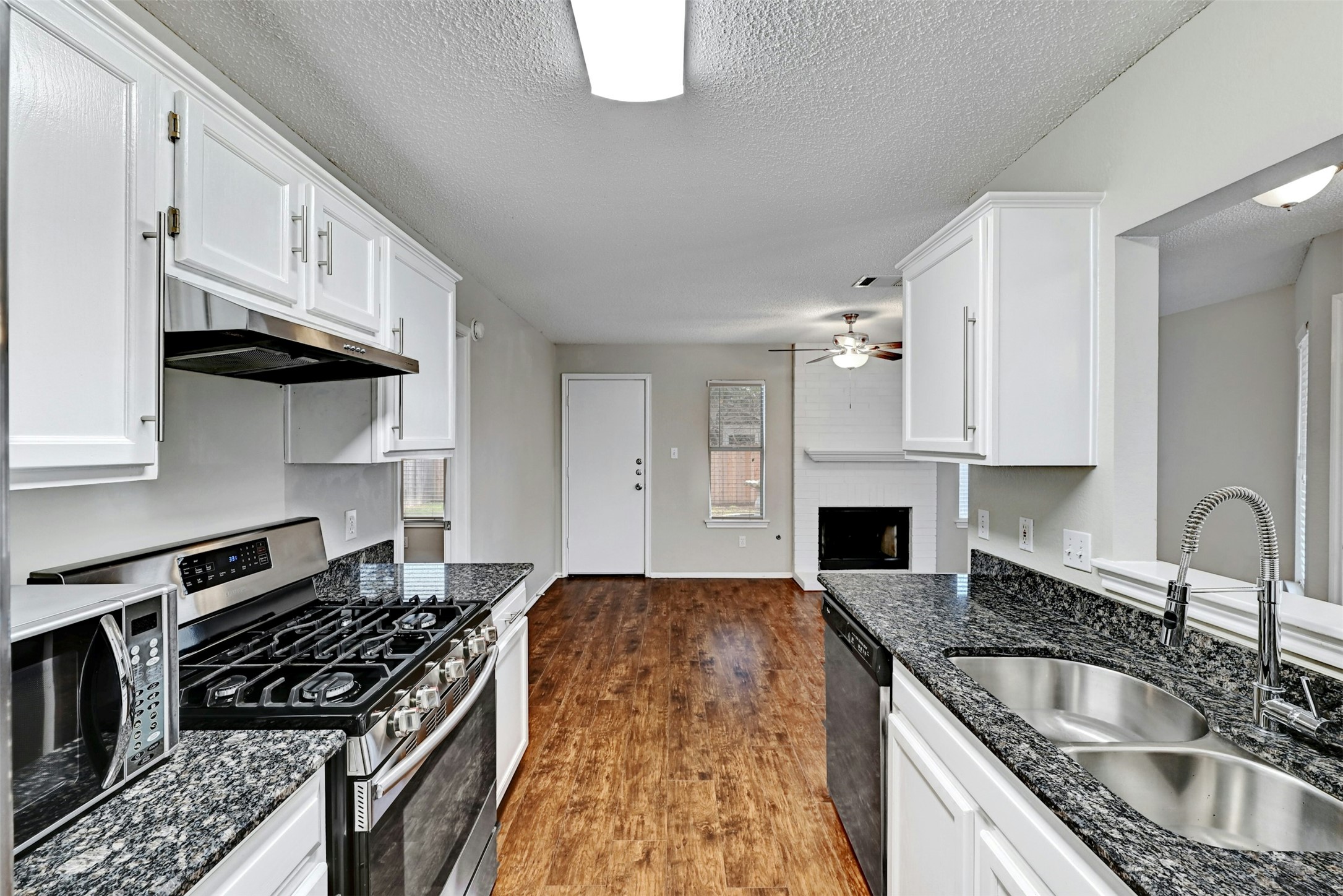 1807 Hollow Tree Boulevard Round Rock, TX 78681 - Photo 16 of 40 a kitchen with granite countertop a stove sink and cabinets