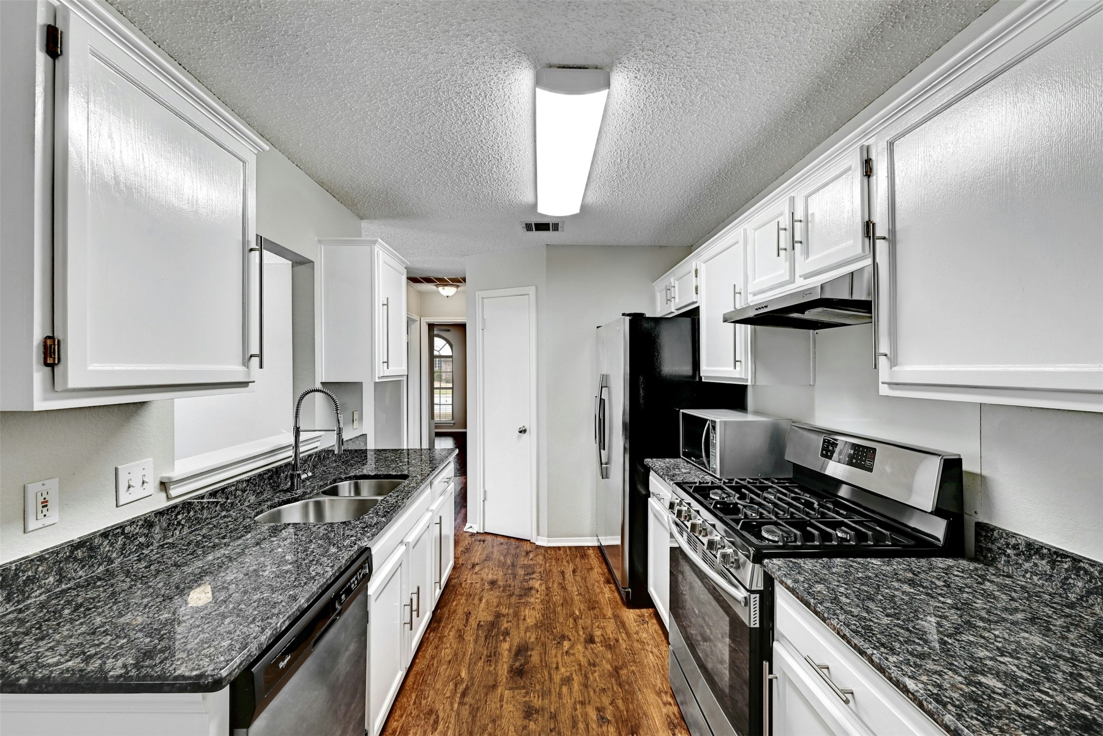 1807 Hollow Tree Boulevard Round Rock, TX 78681 - Photo 18 of 40 a kitchen with granite countertop stainless steel appliances a sink stove top oven and cabinets