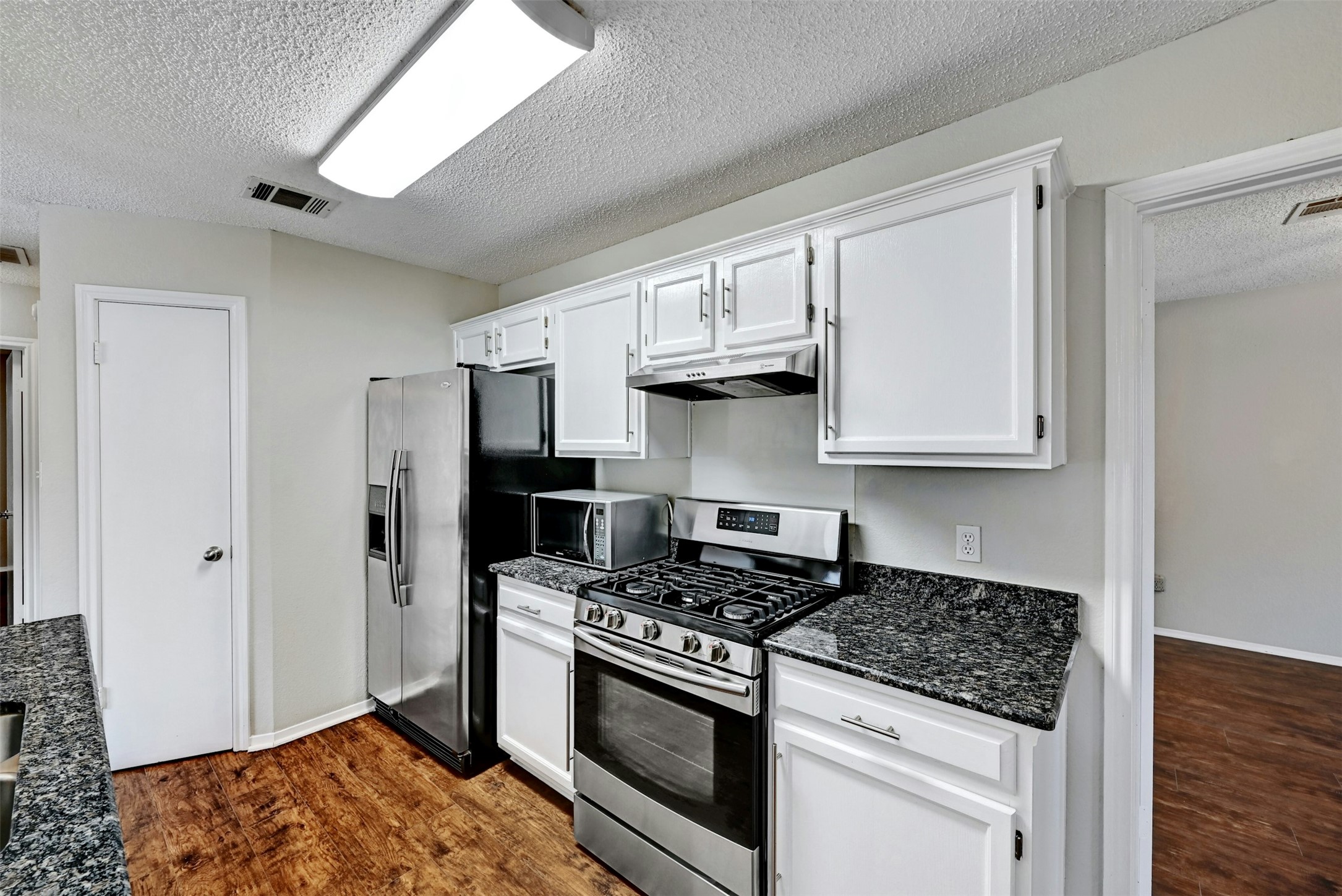 1807 Hollow Tree Boulevard Round Rock, TX 78681 - Photo 19 of 40 a kitchen with stainless steel appliances granite countertop a stove a refrigerator and a sink