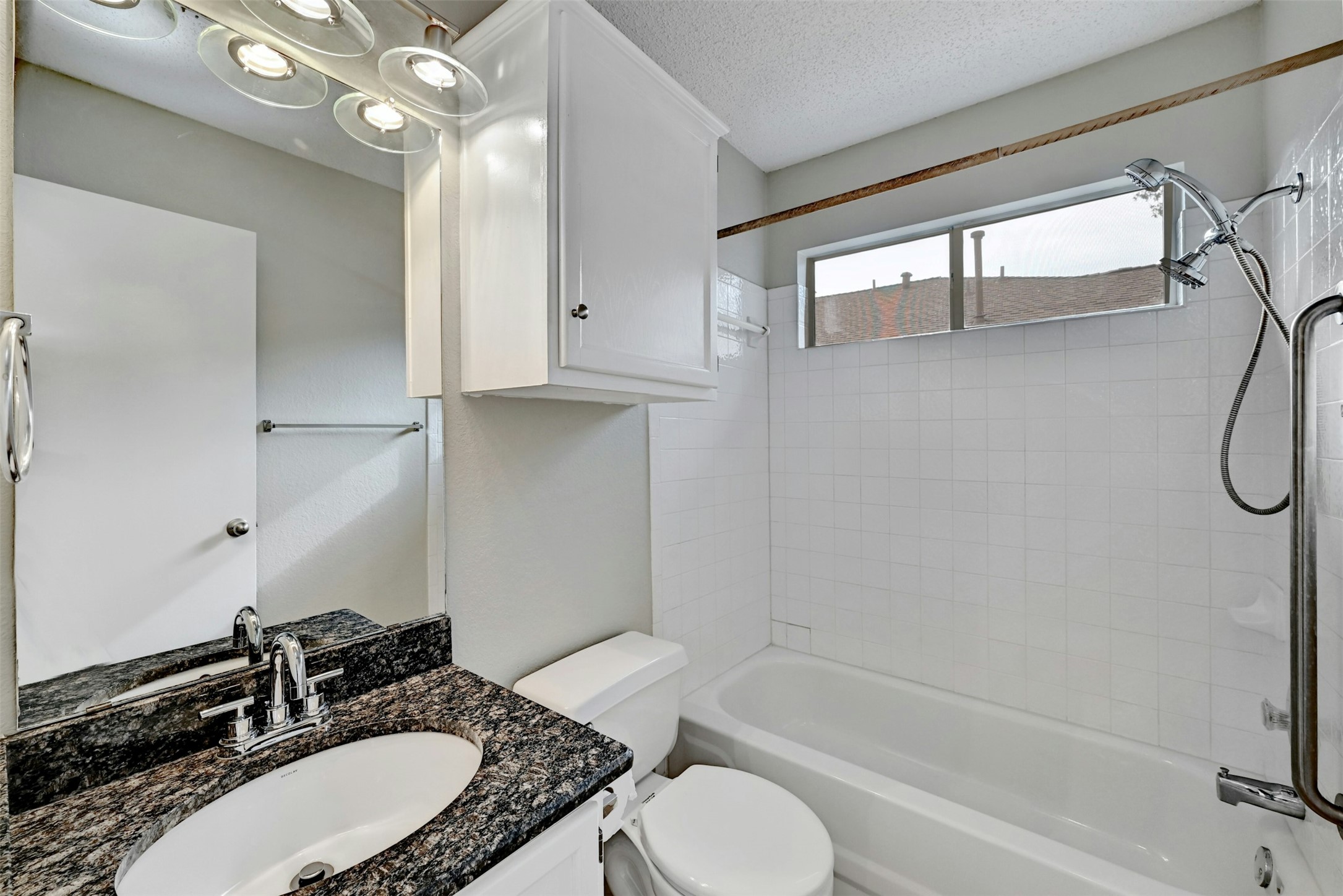 1807 Hollow Tree Boulevard Round Rock, TX 78681 - Photo 30 of 40 a bathroom with a granite countertop sink toilet mirror and a bathtub