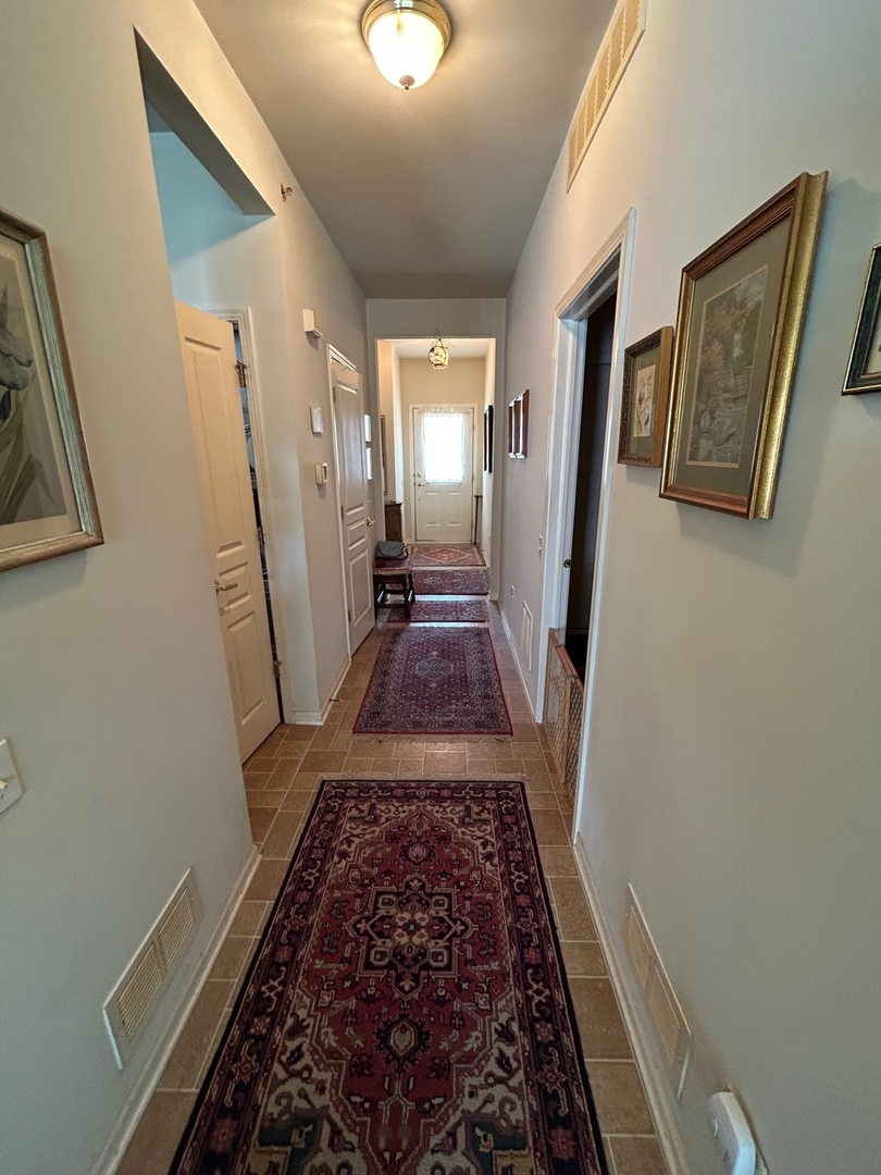 13792 Pineview Drive Huntley, IL 60142 - Photo 8 of 17 a view of a hallway with wooden floor and staircase