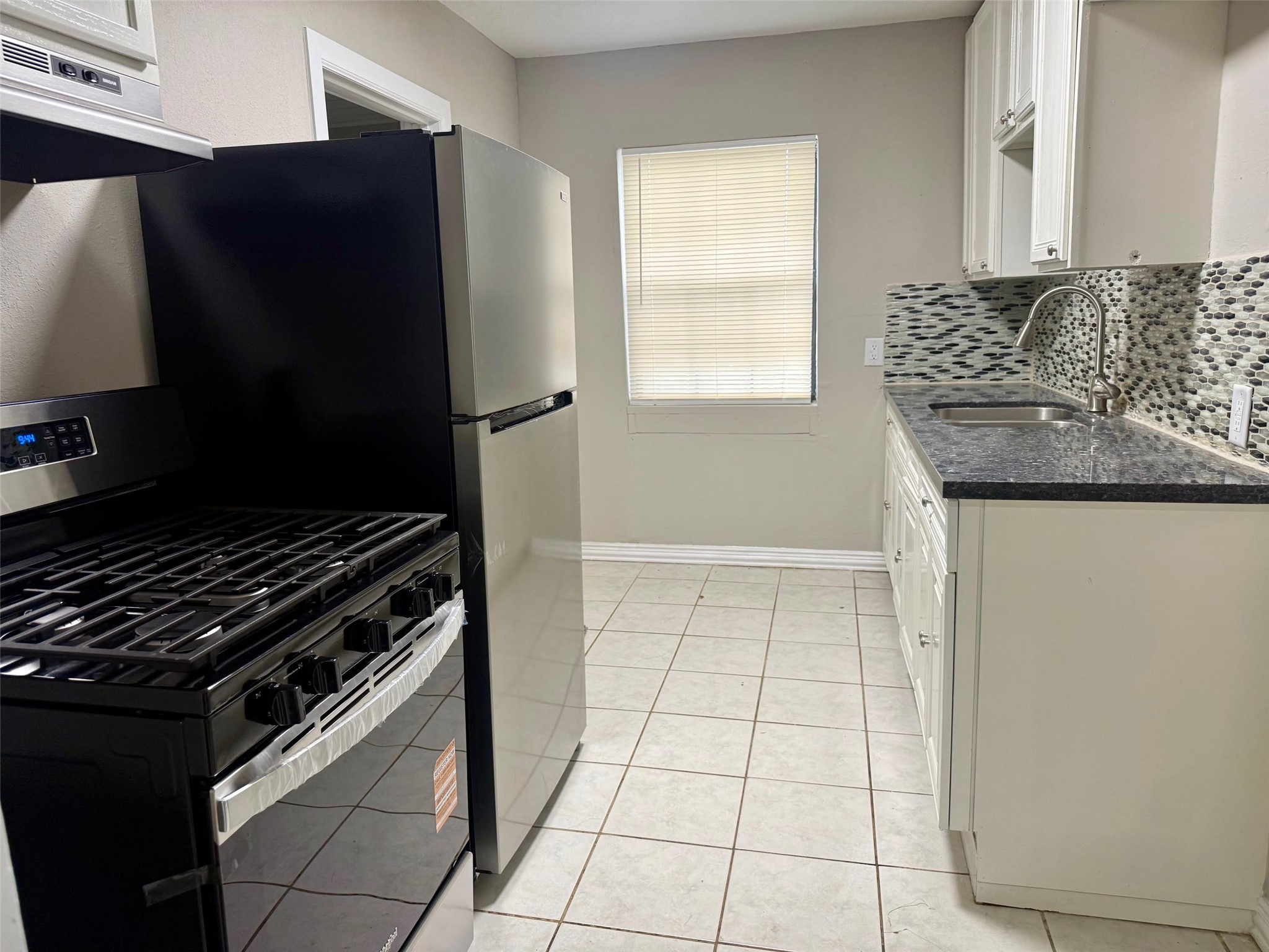 a kitchen with granite countertop a stove and a refrigerator