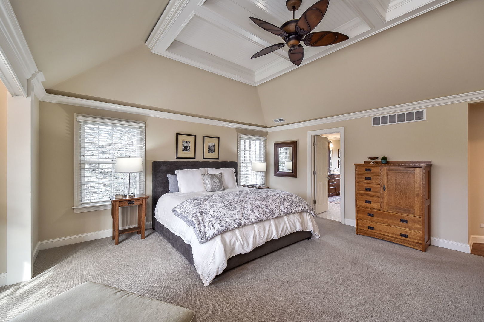 1211 Sunset Road Geneva, IL 60134 - Photo 32 of 65 a spacious bedroom with a bed a dresser and a chandelier