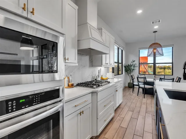 a kitchen with stainless steel appliances a stove sink and cabinets