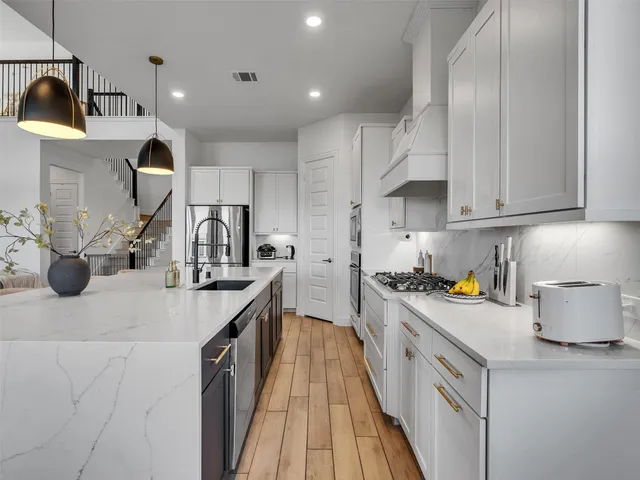 a kitchen with a sink a stove and cabinets