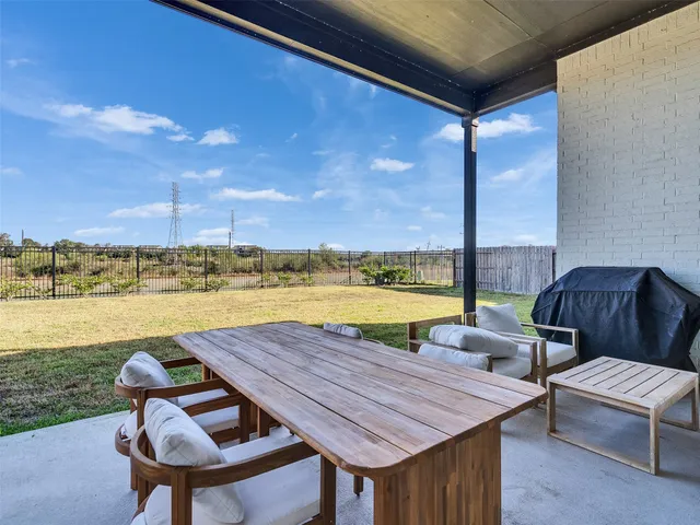 a backyard of a house with table and chairs