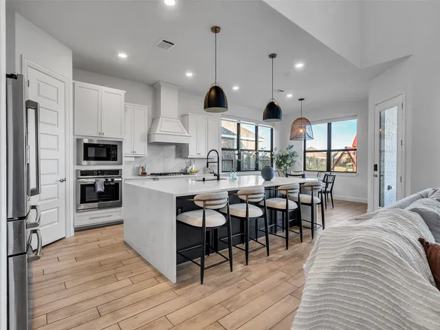 a very nice looking kitchen with dining room and wooden floor
