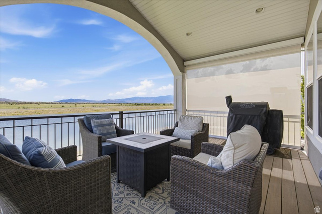 21 Pier Place Tooele, UT 84074 - Photo 85 of 112 Covered outdoor patio featuring a composite deck and a decorative railing overlooking a body of water and distant mountains