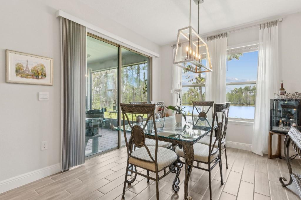 17936 Adrift Road Winter Garden, FL 34787 - Photo 14 of 44 a view of a dining room with furniture large windows and wooden floor