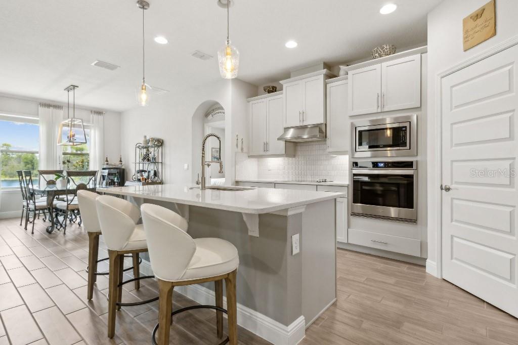 17936 Adrift Road Winter Garden, FL 34787 - Photo 15 of 44 a kitchen with kitchen island granite countertop a table and chairs in it