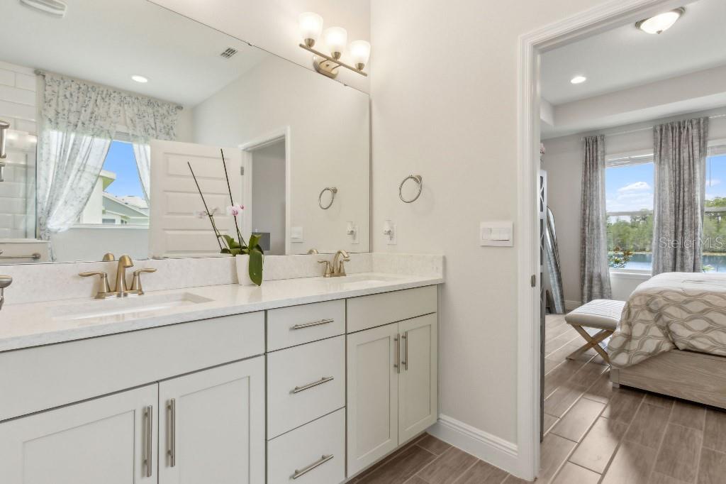 17936 Adrift Road Winter Garden, FL 34787 - Photo 22 of 44 a en suite bathroom with a double vanity sink a mirror a vanity and a bathtub