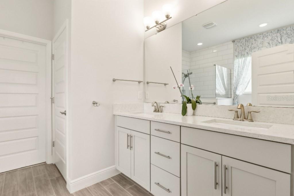 17936 Adrift Road Winter Garden, FL 34787 - Photo 23 of 44 a bathroom with a double vanity sink a mirror and a shower