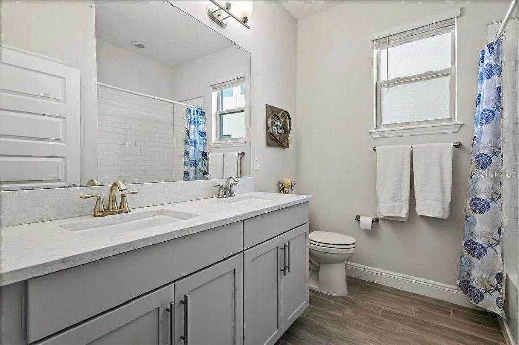 17936 Adrift Road Winter Garden, FL 34787 - Photo 28 of 44 a bathroom with a double vanity sink toilet and a mirror