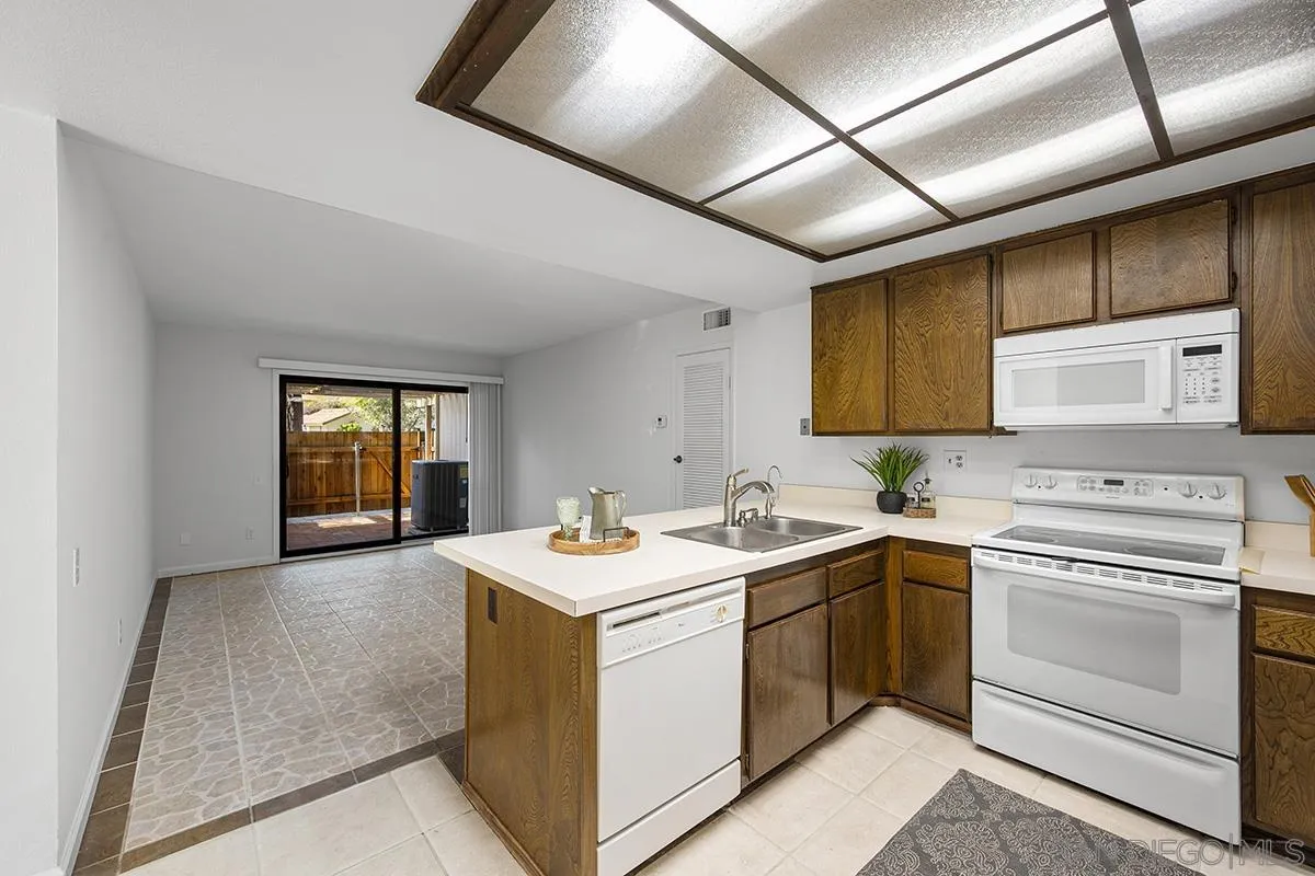 9787 Rimpark Way San Diego, CA 92124 - Photo 13 of 54 a kitchen with a sink stove and cabinets