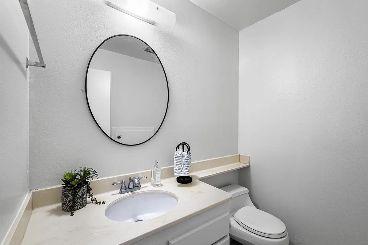 9787 Rimpark Way San Diego, CA 92124 - Photo 18 of 54 a bathroom with a sink a mirror and a toilet