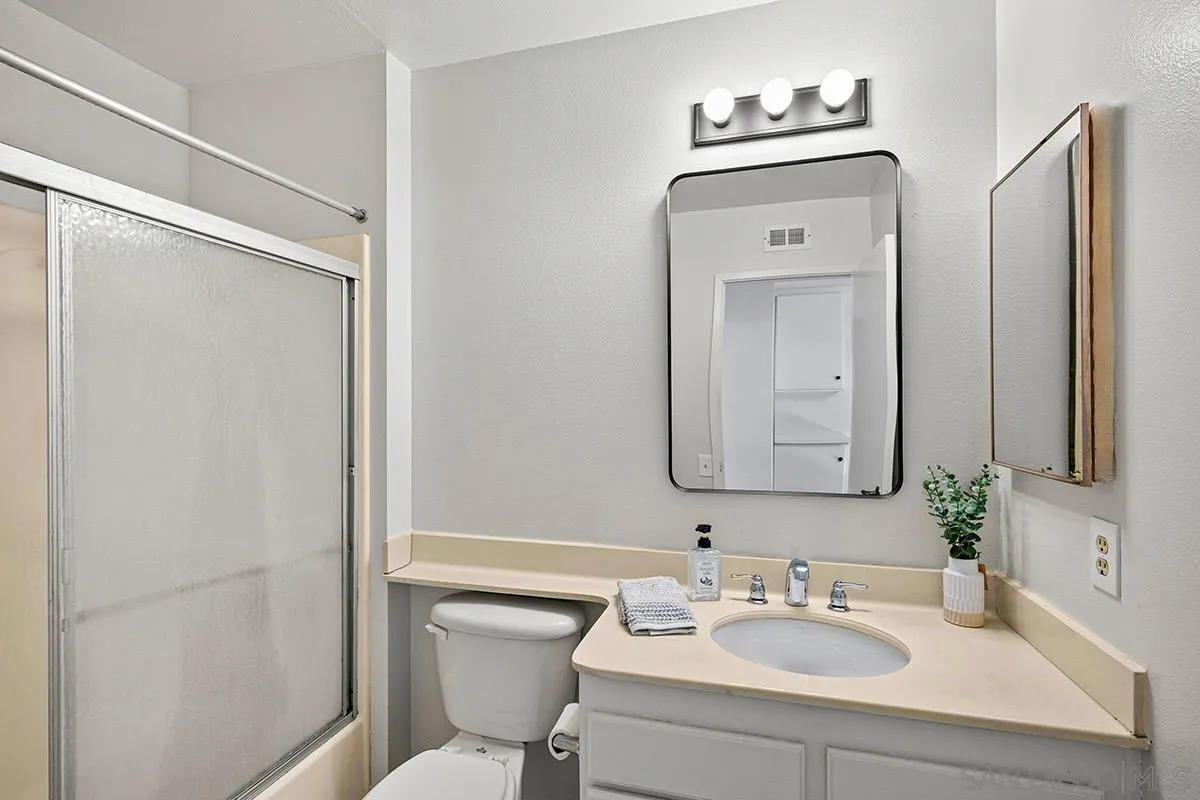 9787 Rimpark Way San Diego, CA 92124 - Photo 27 of 54 a bathroom with a sink toilet and mirror
