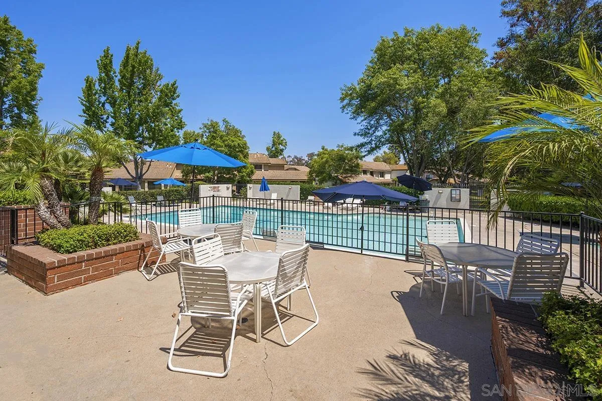 9787 Rimpark Way San Diego, CA 92124 - Photo 49 of 54 a view of a patio with a table and chairs under an umbrella with potted plants