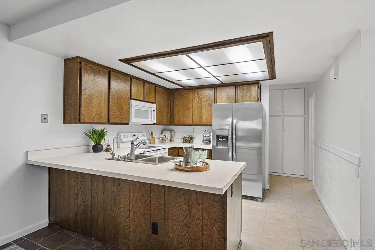 9787 Rimpark Way San Diego, CA 92124 - Photo 8 of 54 a kitchen with stainless steel appliances a sink stove and refrigerator