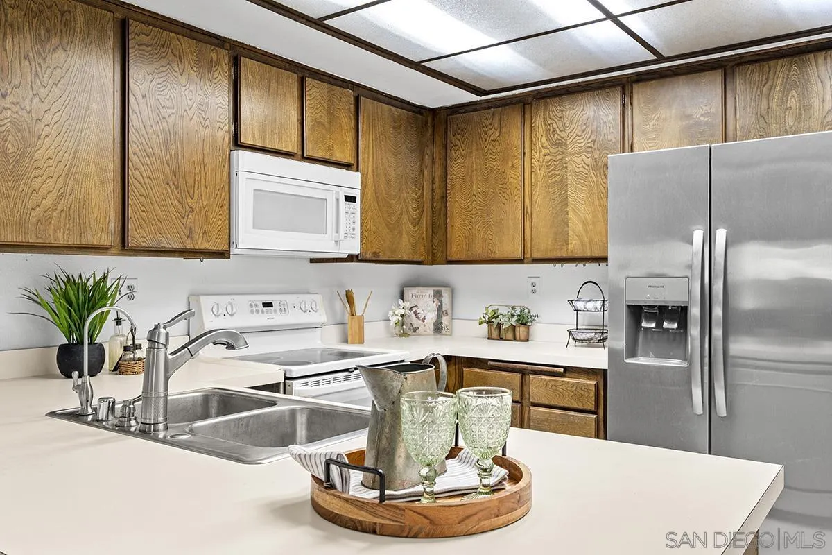 9787 Rimpark Way San Diego, CA 92124 - Photo 9 of 54 a kitchen with a refrigerator and a sink