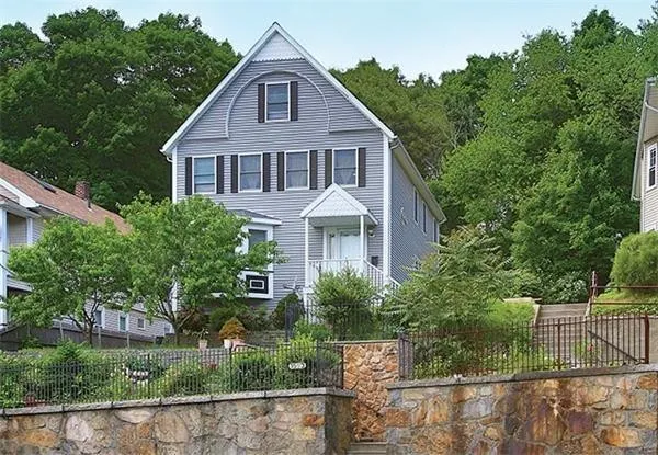 a front view of a house with a yard and potted plants