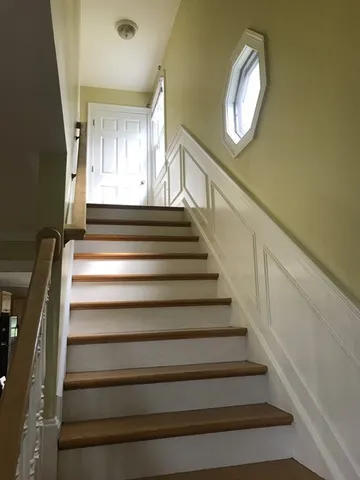 a view of staircase with wooden floor and window