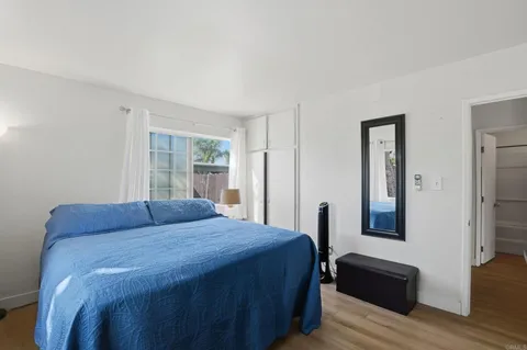 a bedroom with a bed and wooden floor