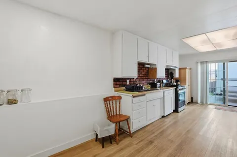 a kitchen with sink cabinets and wooden floor