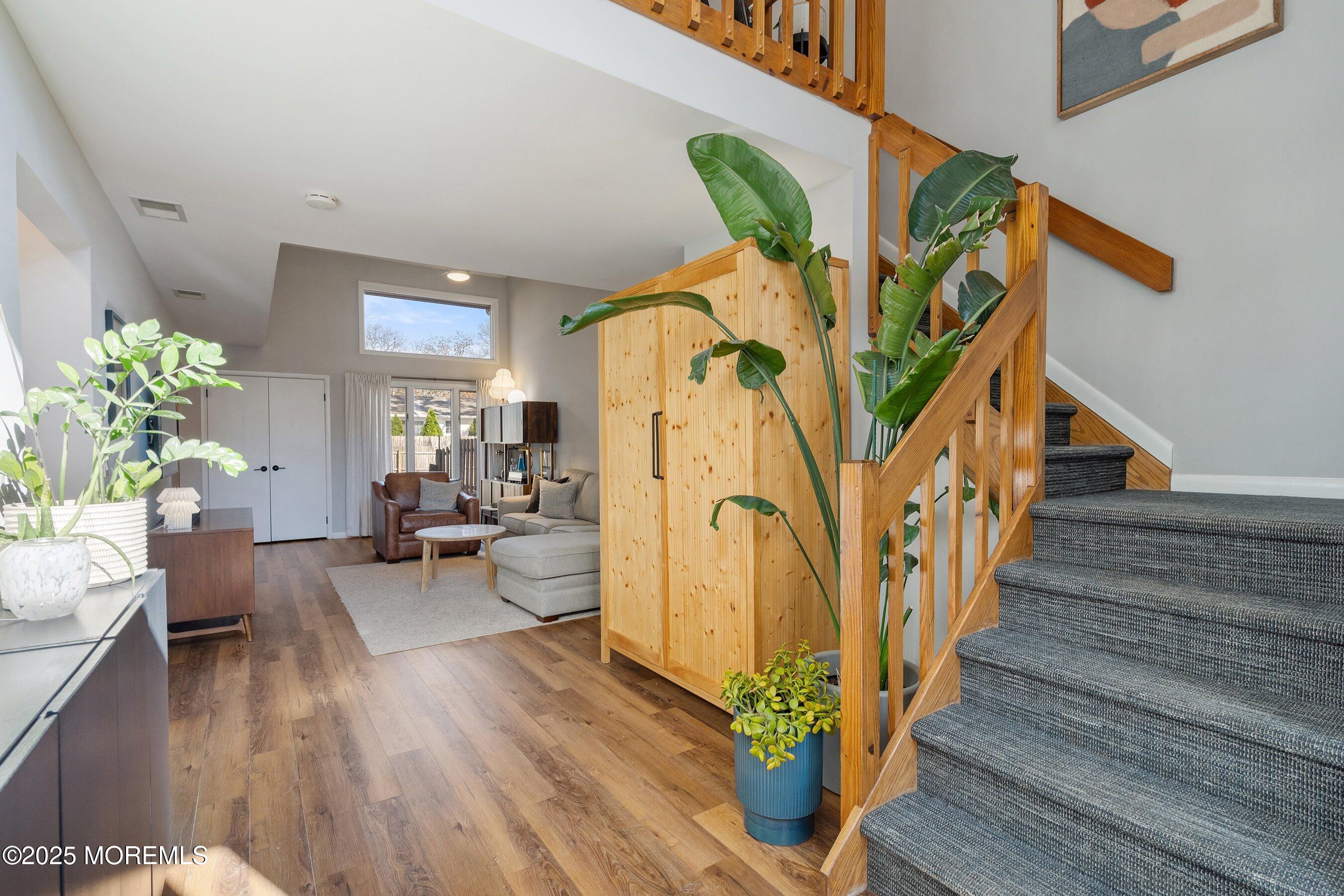 51 White Swan Way Brick, NJ 08723 - Photo 3 of 21 a hallway with wooden floor stairs and furniture