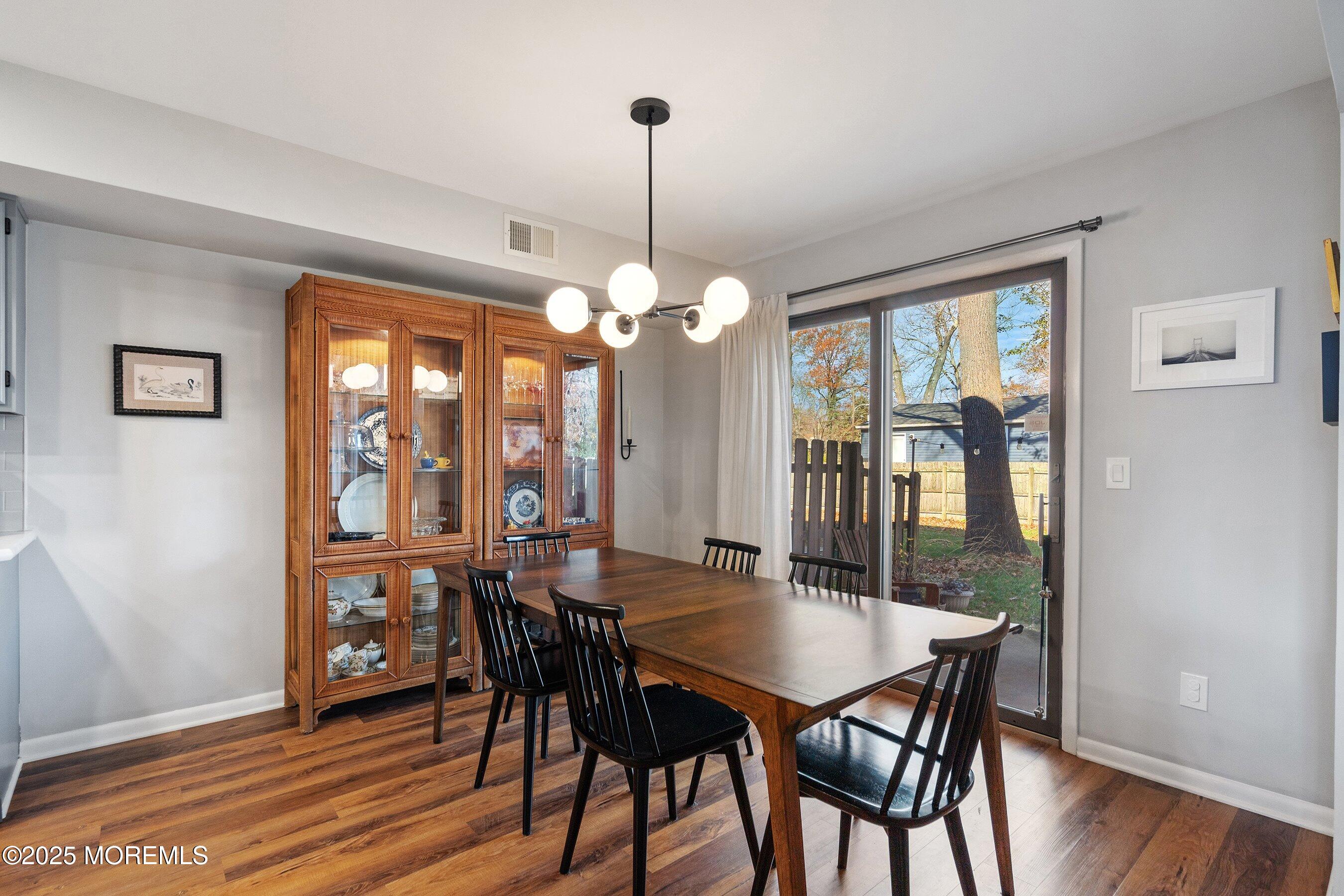 51 White Swan Way Brick, NJ 08723 - Photo 6 of 21 a dining room with furniture a chandelier and wooden floor