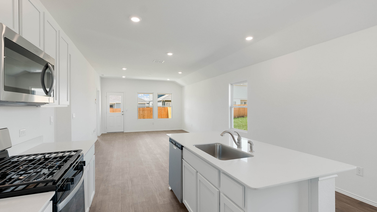 12205 Pike Bend Mustang Ridge, TX 78610 - Photo 6 of 19 a kitchen with stainless steel appliances a sink a stove and microwave