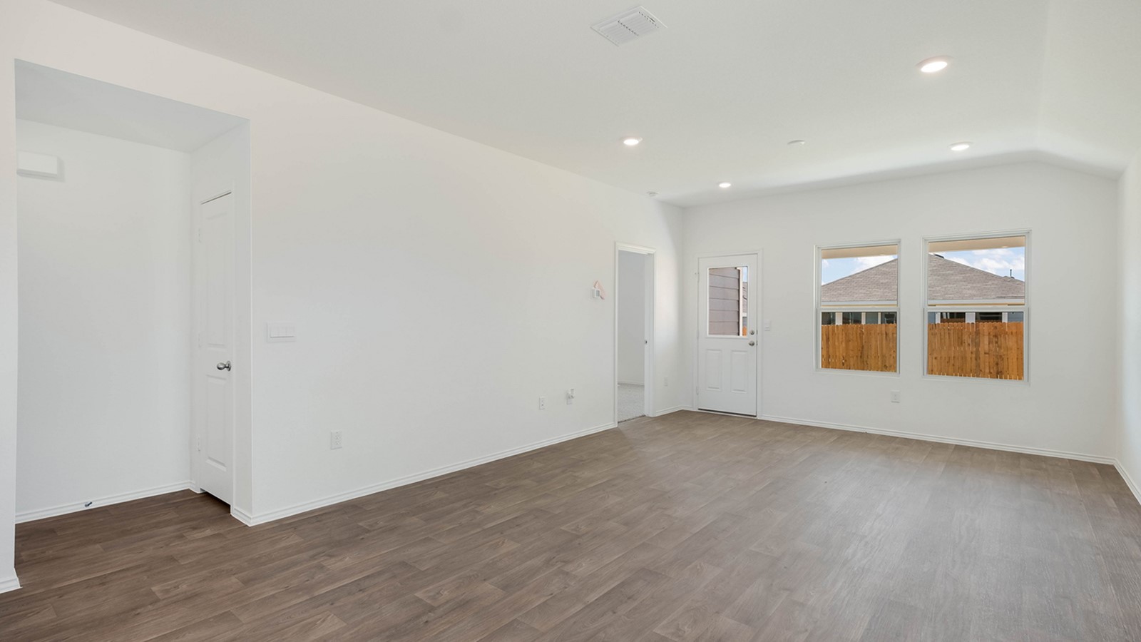 12205 Pike Bend Mustang Ridge, TX 78610 - Photo 8 of 19 an empty room with wooden floor and windows