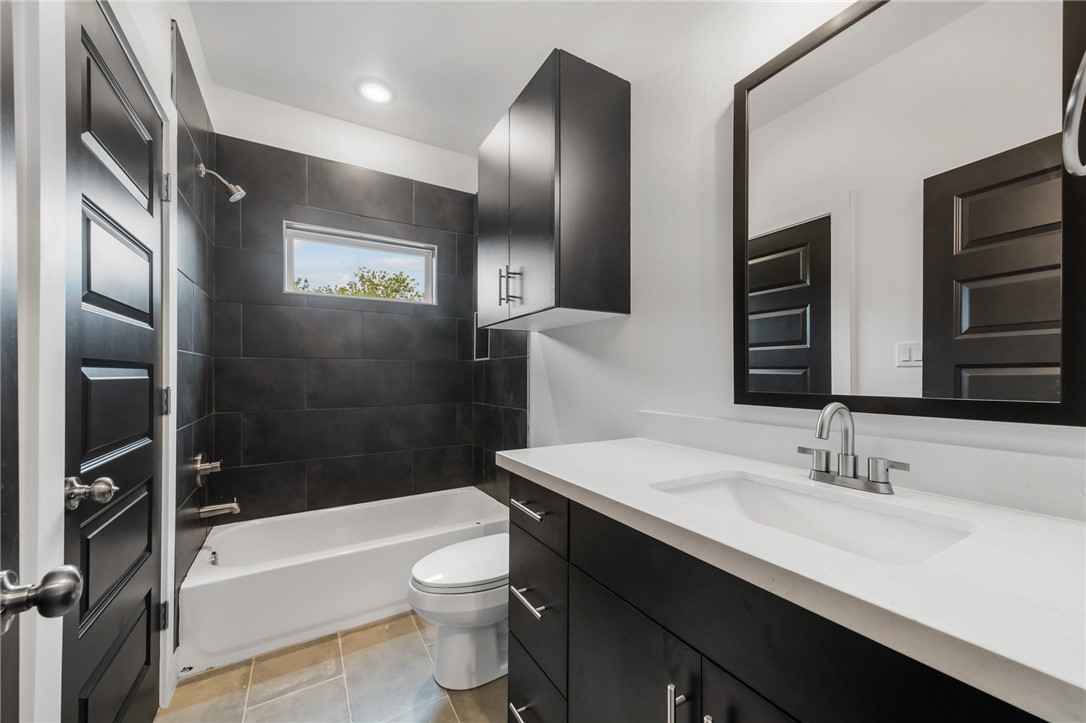 213 Lynn Drive, Unit 202 Bryan, TX 77801 - Photo 13 of 28 a bathroom with a sink a toilet and shower