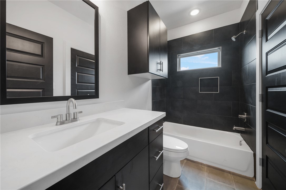213 Lynn Drive, Unit 202 Bryan, TX 77801 - Photo 19 of 28 a bathroom with a sink a toilet and bathtub
