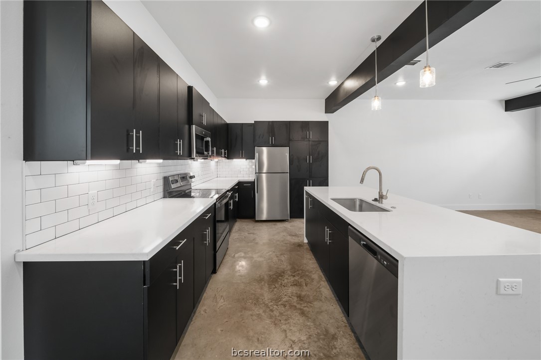 213 Lynn Drive, Unit 202 Bryan, TX 77801 - Photo 4 of 28 a large kitchen with a sink and cabinets