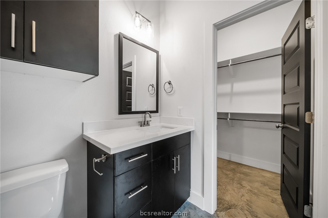 213 Lynn Drive, Unit 202 Bryan, TX 77801 - Photo 8 of 28 a bathroom with a sink toilet a mirror and shower