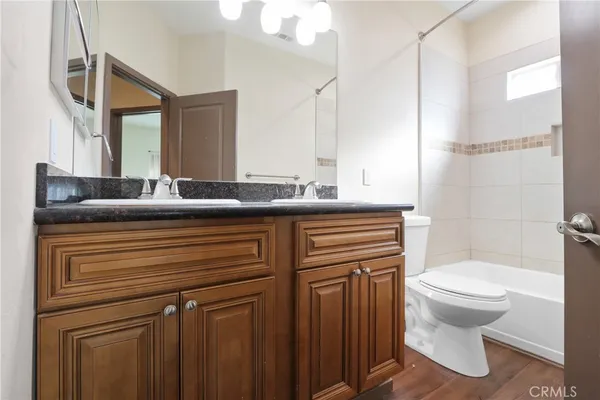 a bathroom with a granite countertop sink toilet and mirror