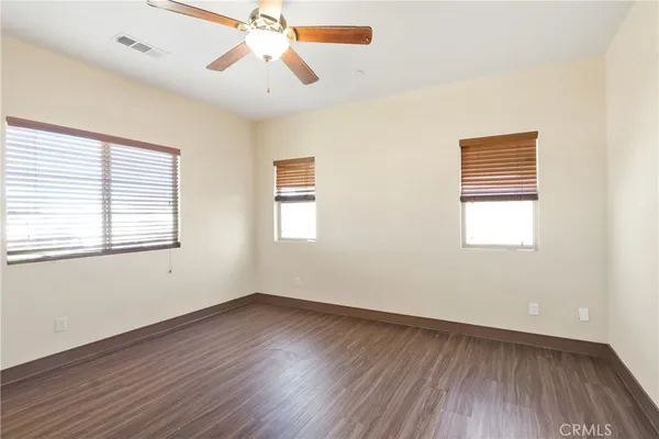 a view of room with hardwood floor and ceiling fan