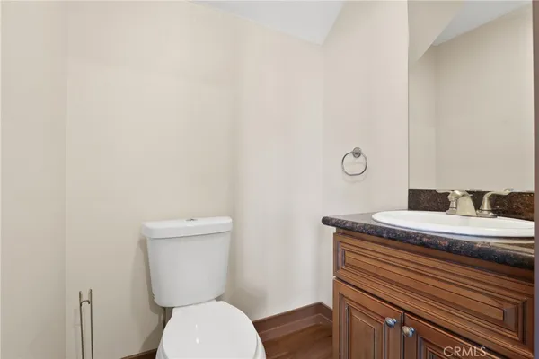 a bathroom with a granite countertop toilet and a sink