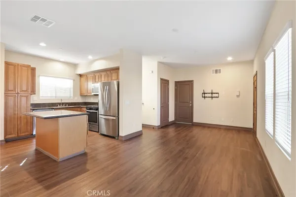 a kitchen with stainless steel appliances a refrigerator and wooden floor