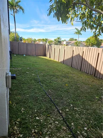 a view of a yard with wooden fence
