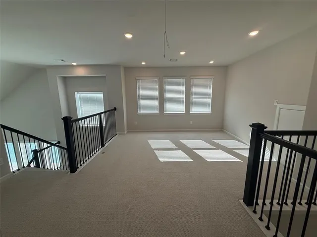 a view of hallway with stairs and a window