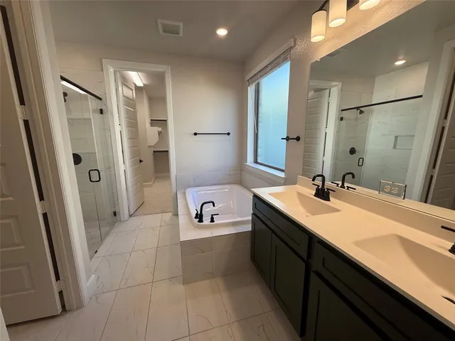 a spacious bathroom with a double vanity sink a mirror and a shower
