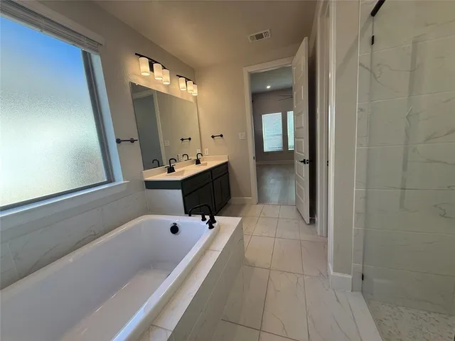 a bathroom with a tub sink and mirror