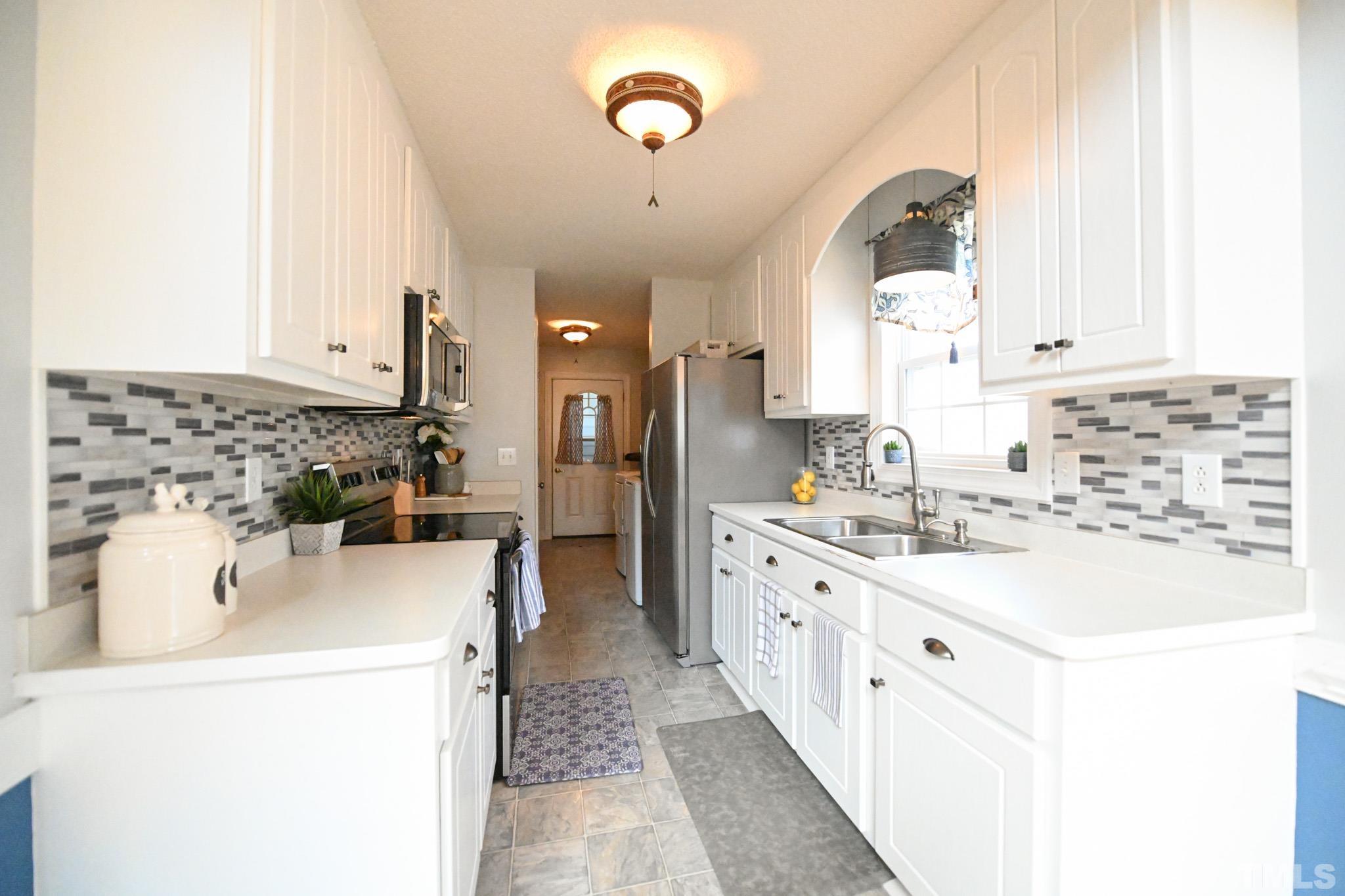 4071 Bizzell Grove Church Road Princeton, NC 27569 - Photo 12 of 53 a kitchen with kitchen island a sink a stove and a refrigerator