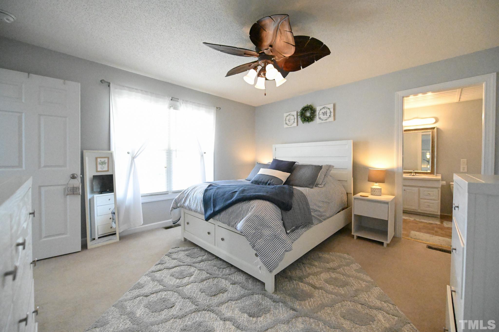 4071 Bizzell Grove Church Road Princeton, NC 27569 - Photo 27 of 53 a spacious bedroom with a bed and a chandelier