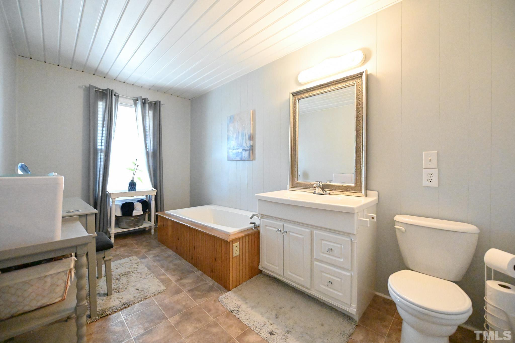 4071 Bizzell Grove Church Road Princeton, NC 27569 - Photo 30 of 53 a bathroom with a toilet a sink a mirror and a window
